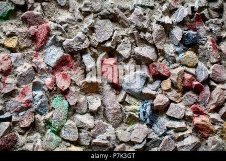 Background texture of multi-colored decorated gravel and cement on the wall of old house as basis for design or decoration. Stock Photo