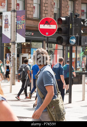 Man looking back at Clet Abraham street art road sign title 'The Clash'  on Buchanan Street, Glasgow, Scotland, UK Stock Photo