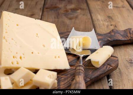 https://l450v.alamy.com/450v/p7k5mw/cheese-with-holes-large-and-small-wooden-board-and-knife-traditional-dutch-cheese-copy-space-p7k5mw.jpg