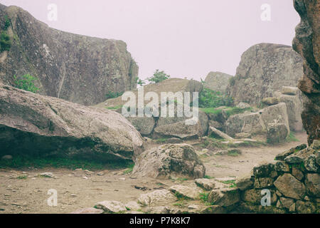 Stones and ruins covered by mist in a mystical environment at Machu Picchu. Peru. South America. No people. Stock Photo