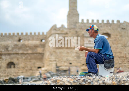 old man with fishing line fishing in front of the fortress Koules or fortress Rocca al Mare, anglers by the sea, Iraklion, Heraklion, Crete, Greece, Europe Stock Photo