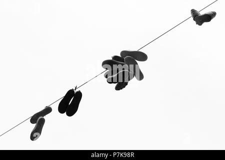 Shoes hanging on a power line. Stock Photo