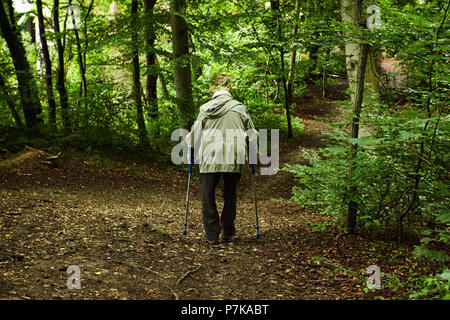 old man Woman 70-90 years with crutches walking in forest Stock Photo
