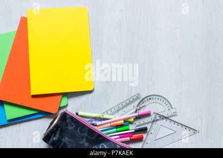 Colorful notebooks on white wooden background with pencil case Stock Photo