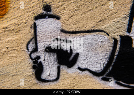 White hand with graffiti spray can painted on a rough concrete yellow and orange wall. Cool urban wallpaper image. Stock Photo