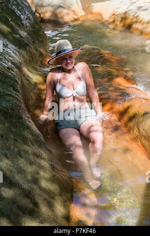 Larissa, Greece. 6th July, 2018. A tourist takes a bath in the spring of curative red water at Kokkino Nero Village of Larissa in northeast Thessaly, Greece, July 6, 2018. Curative red water attracts visitors from all over the world looking for bath therapy along with mineral water drinking therapy. Credit: Apostolos Domalis/Xinhua/Alamy Live News Stock Photo