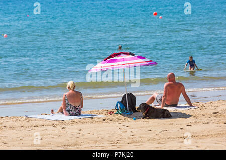 Bournemouth, Dorset, UK. 7th July 2018. UK weather: another hot sunny day as the heatwave continues and thousands of sunseekers head to the  seaside to enjoy the sandy beaches at Bournemouth.  Mature couple sunbathing on the seashore. Credit: Carolyn Jenkins/Alamy Live News Stock Photo