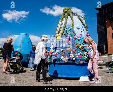 Sunderland, UK 7th July 2018: Local artists put the final touches to their knitted cover for one of SUnderlan's distinctive buoys as the city gears up for the arrival of the Tall Ships next week. The ships will arrive from Monday in advance of the start of the race on Saturday 14th July. (c) Paul Swinney/Alamy Live News Stock Photo