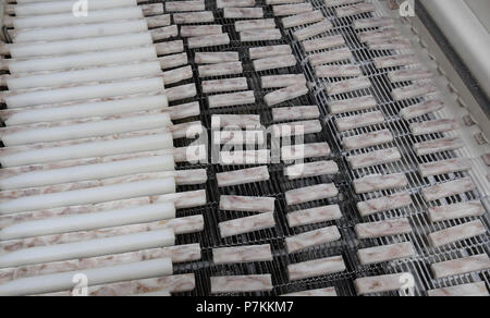 Bremerhaven, Germany. 25th June, 2018. Fish sticks are cut from a block at FROSTA. Credit: Carmen Jaspersen/dpa/Alamy Live News Stock Photo