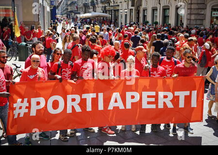 TURIN, ITALY  7th July  2018: FLASH MOB 'A red T-shirt to stop the bleeding of humanity'. Flash mob that was held at the same time throughout Italy to demonstrate in favor of migrants, especially children. Red is the color of the shirts of children who die at sea to reach Europe. Of red were dressed the three children drowned and whose bodies without life were recovered last June 29 in front of the Libyan coasts. Of red will be dressed more by the mothers, in the hope that, in the event of shipwreck, that color recall the attention of the rescuers.Credit: Michele D'Ottavio/Alamy Live News Stock Photo