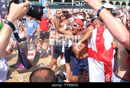 Brighton, UK. 7th July 2018.  England fans celebrate on Brighton beach  as they take the lead through a Harry Maguire goal in the World Cup Quarter Final football match between England and Sweden Credit: Simon Dack/Alamy Live News Stock Photo