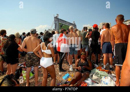 Brighton, UK. 7th July 2018. Football fans on Brighton Beach watching the big screen on the beach through the barriers Credit: Rupert Rivett/Alamy Live News Stock Photo