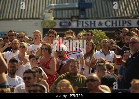 Brighton, UK. 7th July 2018. Football fans on Brighton Beach watching the big screen on the beach through the barriers Credit: Rupert Rivett/Alamy Live News Stock Photo