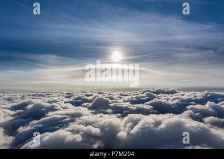 Lenticular cloud above the highest cloud layer, cumulus lenticularis, clouds and sun, cloud flying above northern North Rhine-Westphalia, clouds and blue sky, diffuse sun in blue sky, Neuenkirchen, North Rhine-Westphalia, Germany Stock Photo