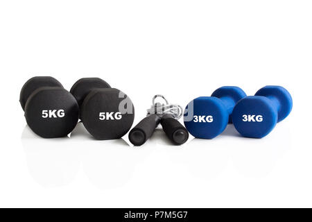 Set of dumbbells and a skipping rope isolated on a white background. Stock Photo