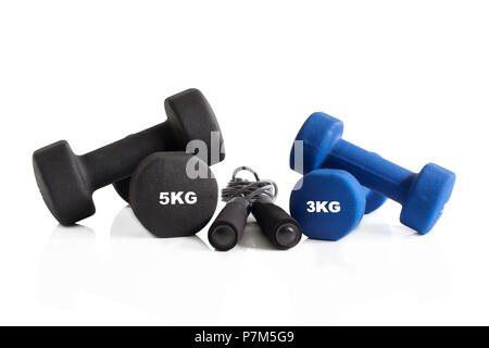 Dumbbells and skipping rope for a gym training isolated on a white background. Stock Photo