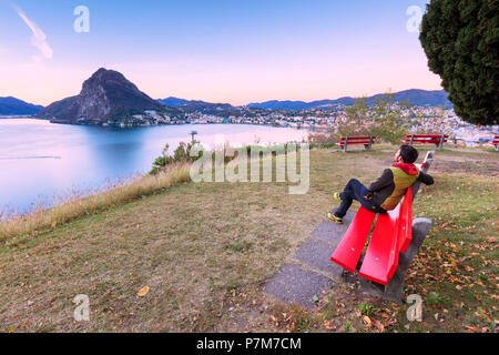 Man on bench on the shore of Lake Lugano Parco San Michele