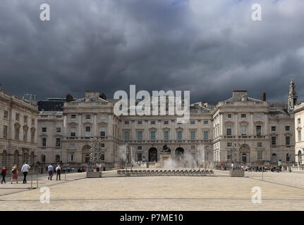 Dramatic picture of the Courtauld Institute of Art in London, England,  partially in bright sunlight, as a menacing dark gray cloud approaches over it Stock Photo