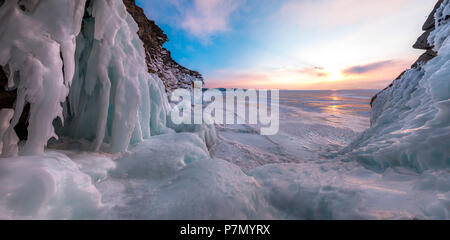 A panoramic picture the the ice stalactites in a cave at the shore at sunset at lake Baikal, Irkutsk region, Siberia, Russia Stock Photo