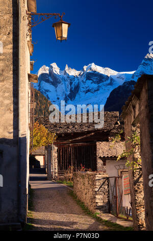 Typical path of the alpine village of Soglio at sunset, with Sciora mountains in the background, Soglio, Val Bregaglia, Grisons, Switzerland, Europe Stock Photo