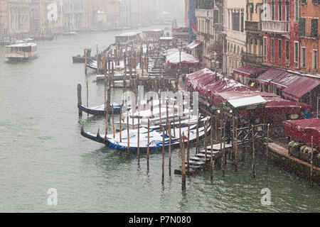 Some traditional venetian gondolas moored in Grand Canal during a snowfall, Venice, Veneto, Italy Stock Photo