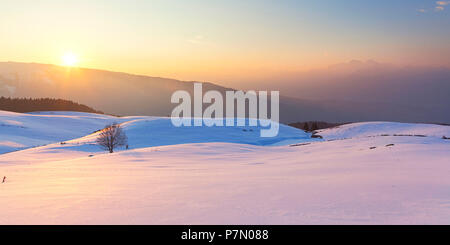 The snowy pastures of Mezzomiglio at sunset, Prealps of Belluno, Farra d'Alpago, Belluno province, Veneto, Italy Stock Photo