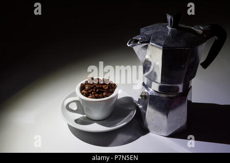 coffee cup full of roasted coffee beans and moka coffee pot Stock Photo