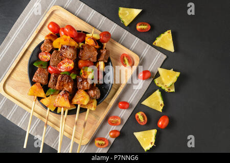 Grill beef barbecue with vegetables in wood plate and on black table, copy space for input text Stock Photo