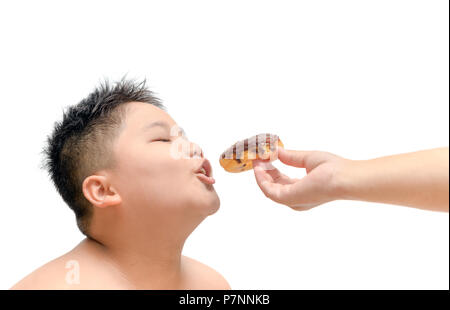 Obese fat boy is eating donut from mother hand isolated on white background, junk food and dieting concept Stock Photo