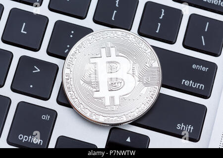 Silver bitcoin isolated on computer key board background. Stock Photo