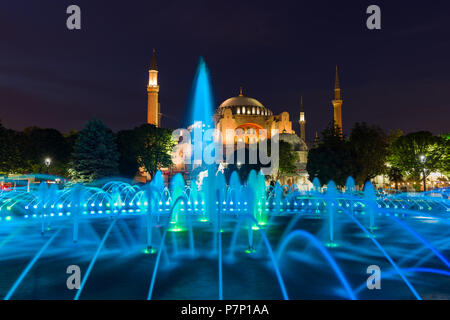 The Sultan Ahmad Maydan water fountain lit up with the Hagia Sophia museum in background at dusk, Istanbul, Turkey Stock Photo