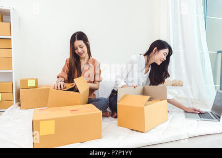 Young Asian woman startup small business entrepreneur SME distribution warehouse with parcel mail box. Owner home office concept. Online marketing and