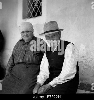 Old couple sitting on a bench and smiling at the camera, around Freiburg from 1945 to 1955 Stock Photo