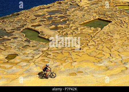 Mountain biking near Gozo salt pans, Xwejni Bay, Gozo Island, Malta Stock Photo