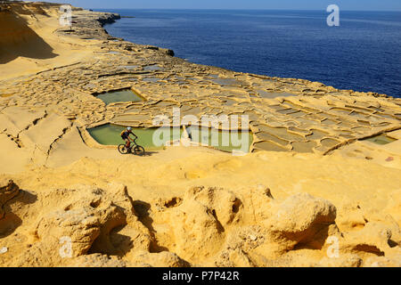 Mountain biking near Gozo salt pans, Xwejni Bay, Gozo Island, Malta Stock Photo