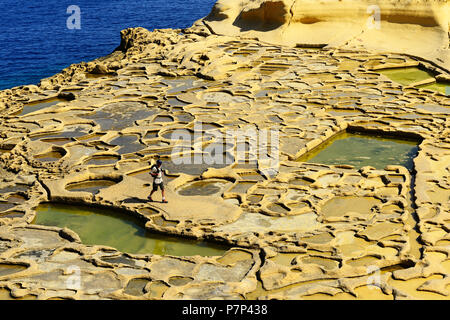 Hiker at Gozo Salt Pans, Xwejni Bay, Gozo Island, Malta Stock Photo