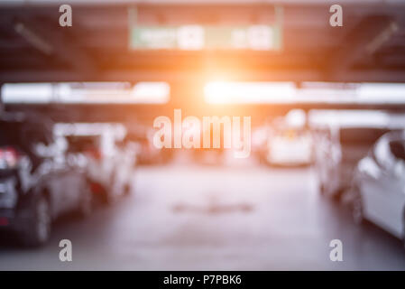 Blurry of car parking lots at department store with orange sun light. Abstract and transportation concept. Stock Photo