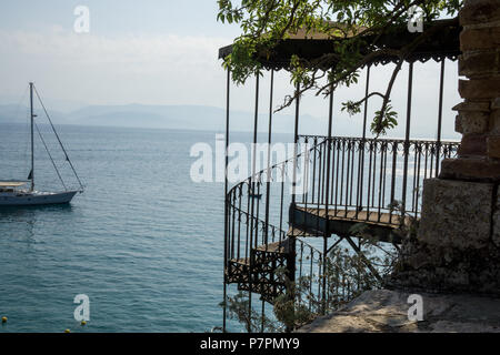 old spiral staircase heading down to the beach in corfu Stock Photo