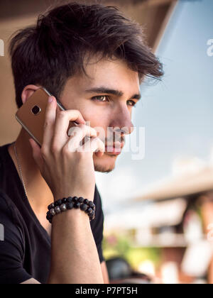 Young man outdoors talking on cell phone Stock Photo