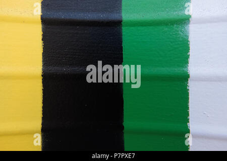 Metallic rolling shutter painted in yellow, black, green and white. Stock Photo
