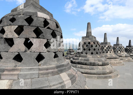 Borobudur, Indonesia - June 23, 2018: Perforated stupas – each containing a statue of Buddha – on the upper level of the Buddhist temple of Borobudur, Stock Photo
