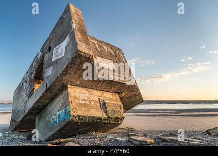 The ruins of a WWII German bunker seem to be stranded on a beach in the Bay of Somme. It is covered with graffiti Stock Photo