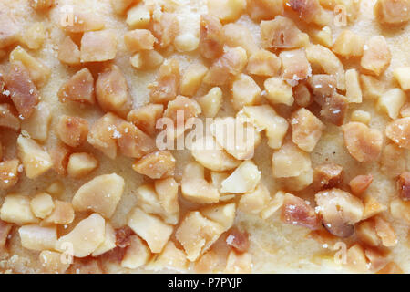 Sliced roasted peanuts on the surface of a shortbread cookie. Studio macro food background Stock Photo