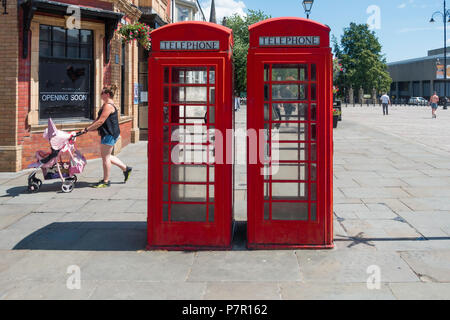 Two classic red British telephone boxes type K6 still in use in Darlington Market Place Durham England. Stock Photo