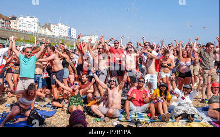 Brighton UK 7th July 2018  - England fans celebrate the second goal scored by Dele Alli against Sweden as they watch a giant screen on Brighton beach  in the World Cup Quarter Final football match between England and Sweden Stock Photo