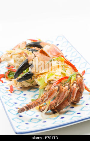 An edible crab, Cancer pagurus, caught in the English Channel in a pot. It has been boiled and then quartered before being fried with fresh ginger, ga Stock Photo