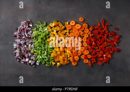 Flat lay sliced fresh vegetables on dark background. Top view Stock Photo