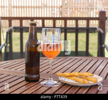 Beer Rose wine and some bread sticks on a garden table on a very hot summers day. Stock Photo