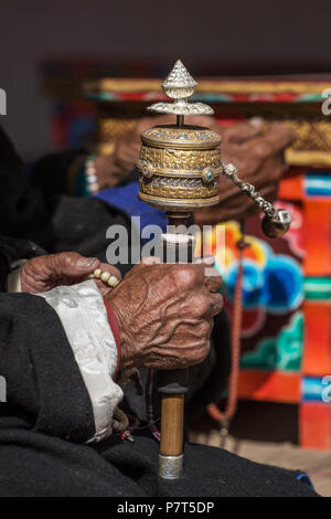 Old mans hands  holding prayer buddhist wheel in Lamayuru monastery, Ladakh, Jammu and Kashmir, India. Stock Photo
