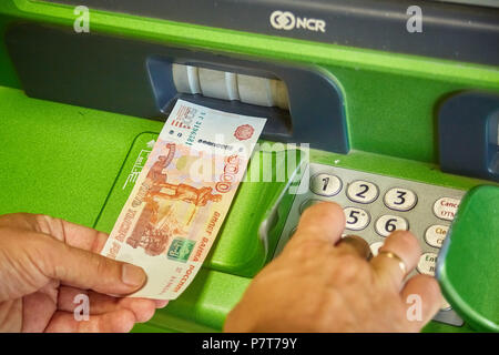 Syzran, Russia - June 20 , 2018: finance, money, bank and people concept - close up of hand taking receipt from atm machine of the Sberbank Stock Photo